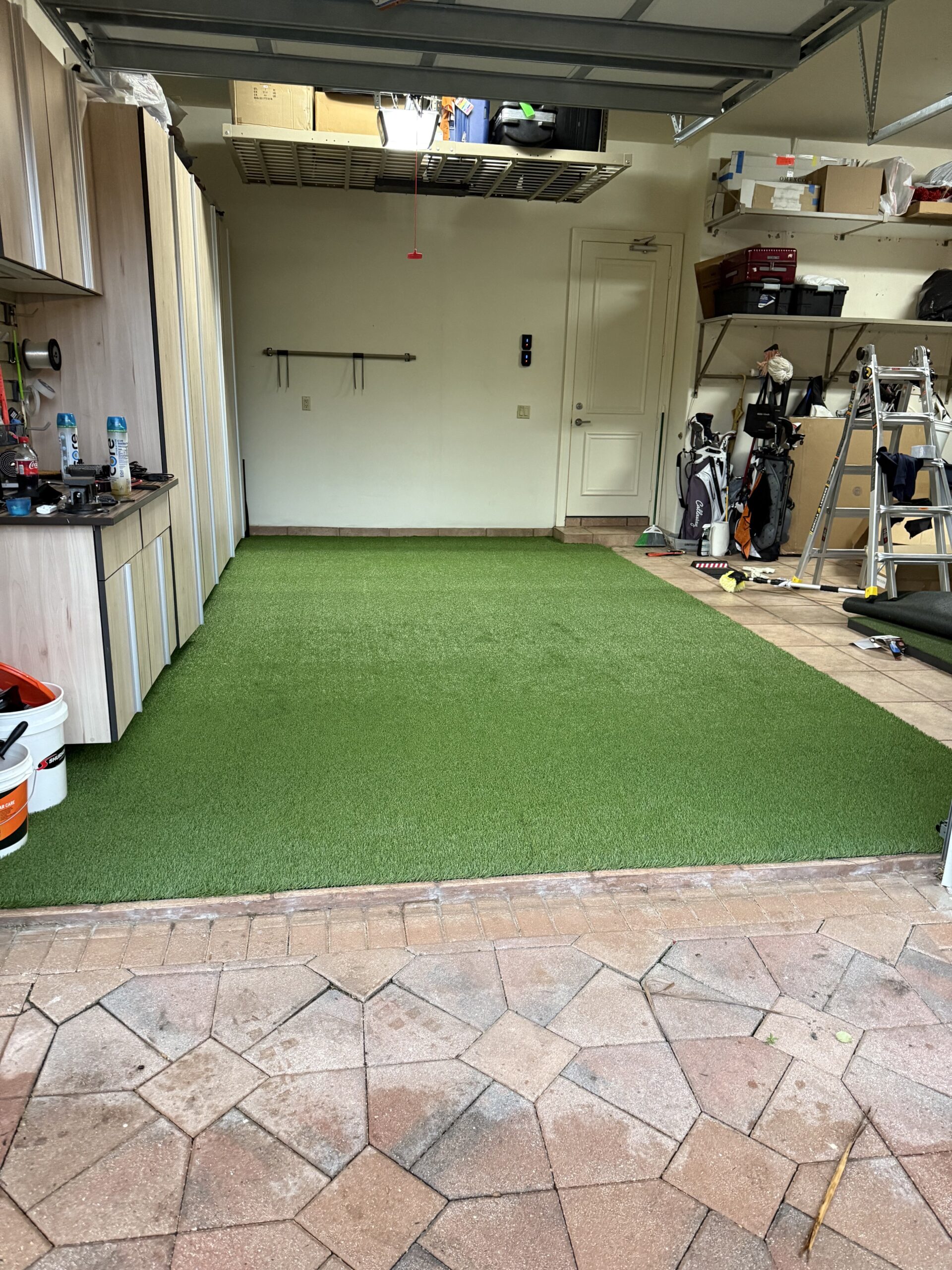 Indoor golf simulator with integrated pro putting turf and break options.