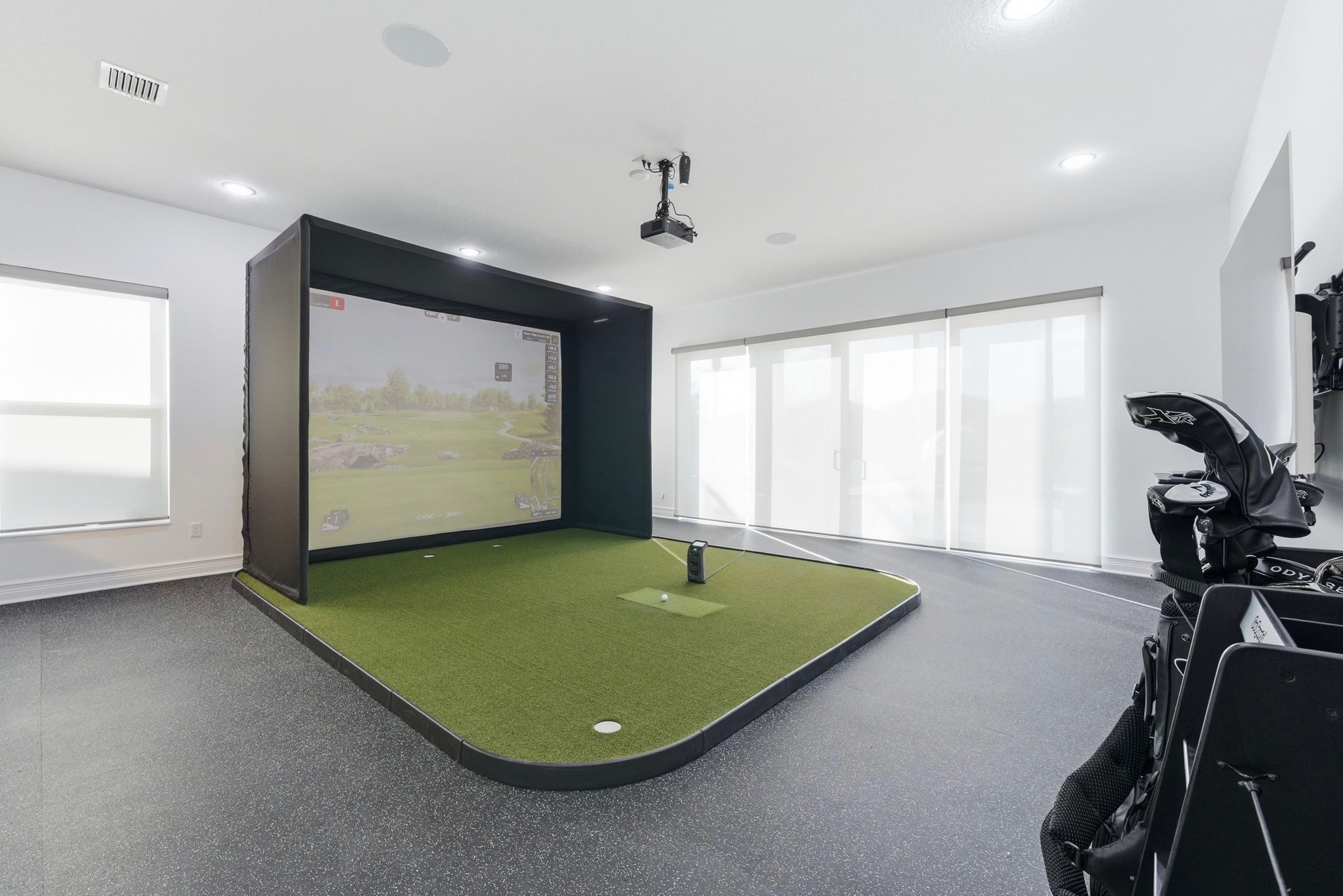 Luxury Golf Simulator installation in a modern home featuring a premium impact screen, projector, turf flooring, and professional simulator setup by GOLF365.